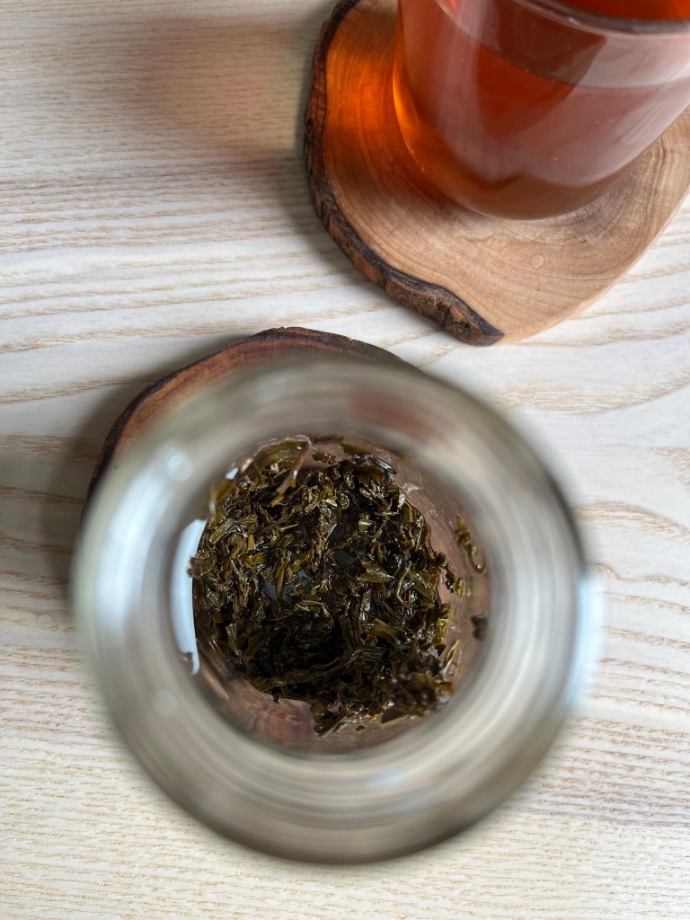 Top-down view of the glass cold brew bottle with wet leaf in the bottom