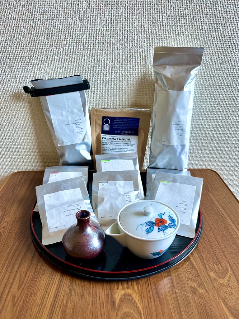 Kyoto tea haul: 9 small tea packets, a little vase, and a white porcelain houhin with blue and white floral illustrations