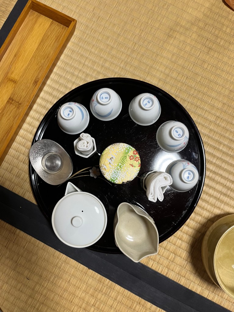 A black circular tray set up for sencha ceremony